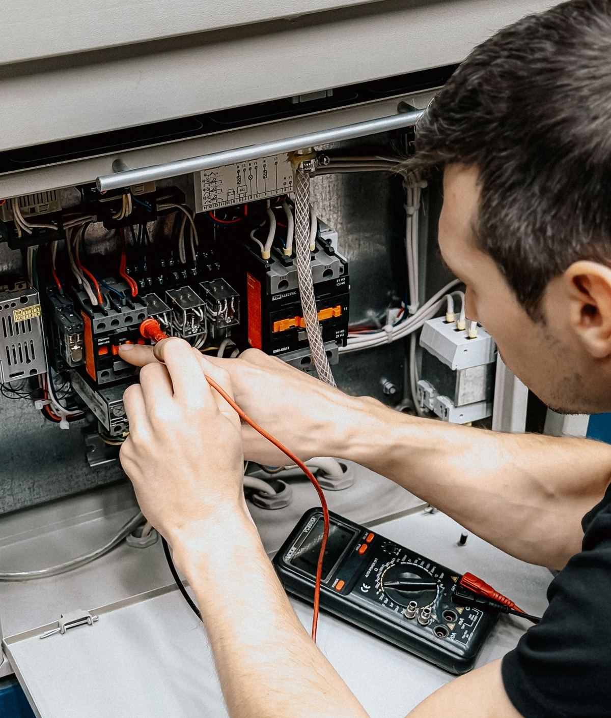 Electrician diagnosing an industrial control panel